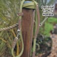 A Custom 2m Multi-way Double-ended Lead with an optional traffic handle is draped over a wooden post outdoors, with greenery and rocks softly blurred in the background. An arrow points to the handle, labelled "Optional Traffic Handle.