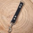 The Super-grip Biothane Training Tab/Obedience Lead - 51cm/20in (Copy), a black textured lead with silver studs and metal fittings, is displayed on a round wooden surface with visible tree rings.