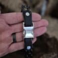 Handmade BioThane dog collar with silver buckle and studded detail held in hand, showcasing durable waterproof design.