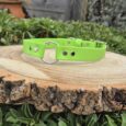 Bright lime-green Biothane centre O-ring gundog collar displayed on natural wood, featuring metal hardware and safety design for active dogs.