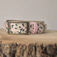 Printed hound collar in blush pink and cream with black abstract pattern, featuring antique brass hardware and quick-snap buckle on wooden surface.