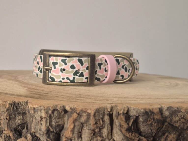 Printed hound collar in blush pink and cream with black abstract pattern, featuring antique brass hardware and quick-snap buckle on wooden surface.