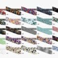 Vibrant collection of printed Biothane dog collars displaying diverse patterns including skulls, florals, argyle, houndstooth, rainbows, and geometric designs.