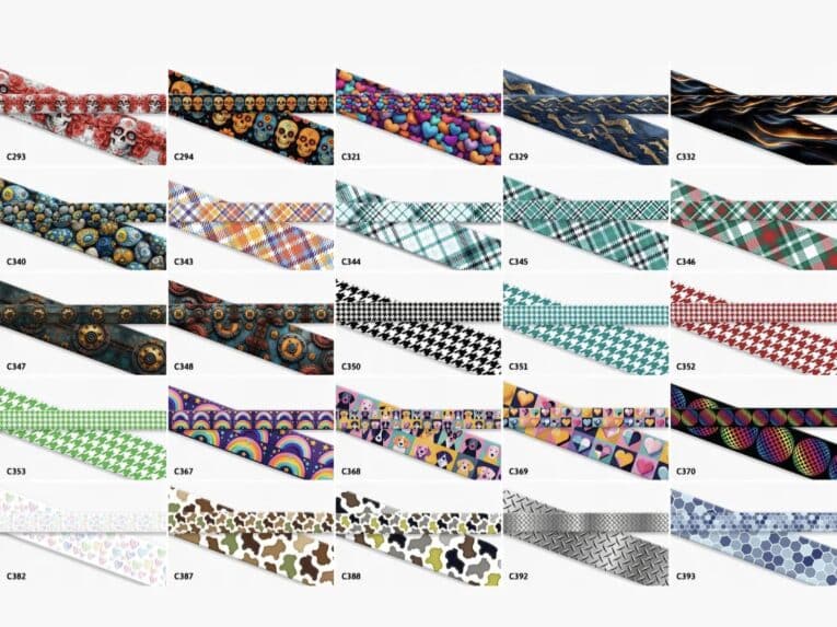 Vibrant collection of printed Biothane dog collars displaying diverse patterns including skulls, florals, argyle, houndstooth, rainbows, and geometric designs.