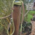 Avocado-coloured BioThane dog collar with optional traffic handle, displayed on wooden post outdoors.