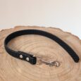 Black BioThane dog lead with grip tag attached to natural wood slice, featuring metal hardware.
