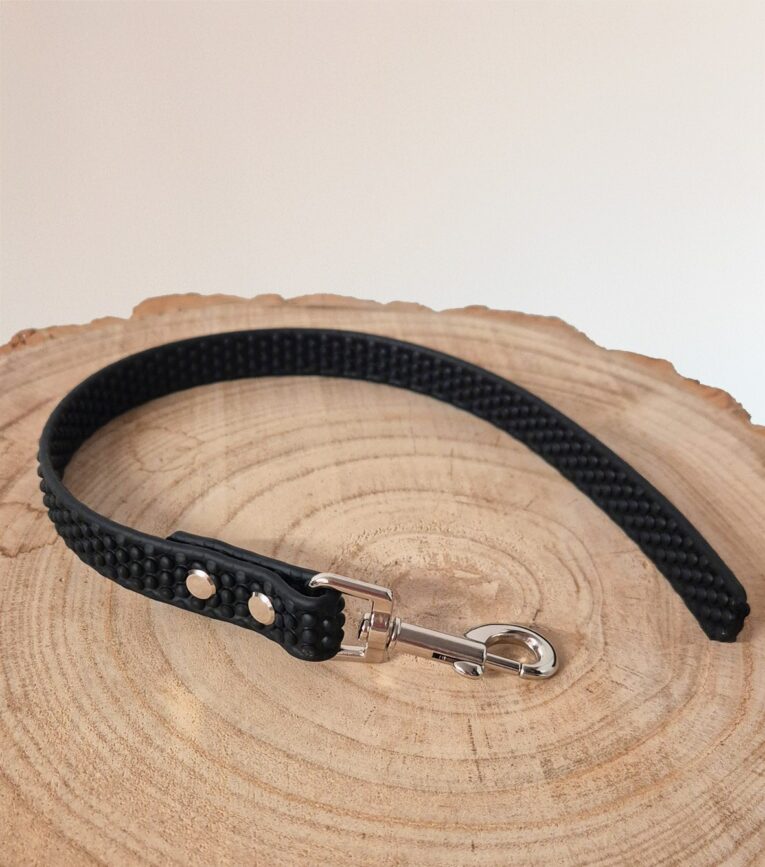 Black BioThane dog lead with grip tag attached to natural wood slice, featuring metal hardware.