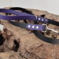 Midnight amethyst and black handmade BioThane dog collars and lead displayed on textured stone.