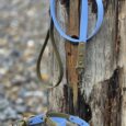 Handmade BioThane dog collar and lead set in blue and olive, displayed on weathered beach wood.