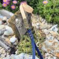 Handmade BioThane dog lead with cream handle and navy lead, displayed outdoors among flowers.