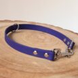 Handmade BioThane slip and clip dog collar in royal blue with silver hardware on natural wood.