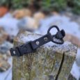 Black BioThane ecollar replacement strap with bungee cord and metal hardware, displayed on weathered wood.