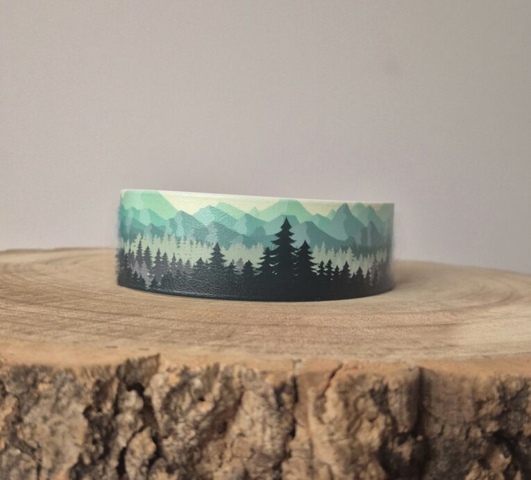 Forest print handmade BioThane dog collar featuring layered mountain and evergreen tree design in green and black tones.