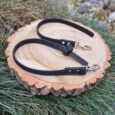 Black BioThane obedience lead with textured finish and silver hardware, displayed on a wooden log.