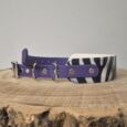 Purple BioThane patterned tapered collar with zebra-striped detail and metal D-rings on wooden surface.