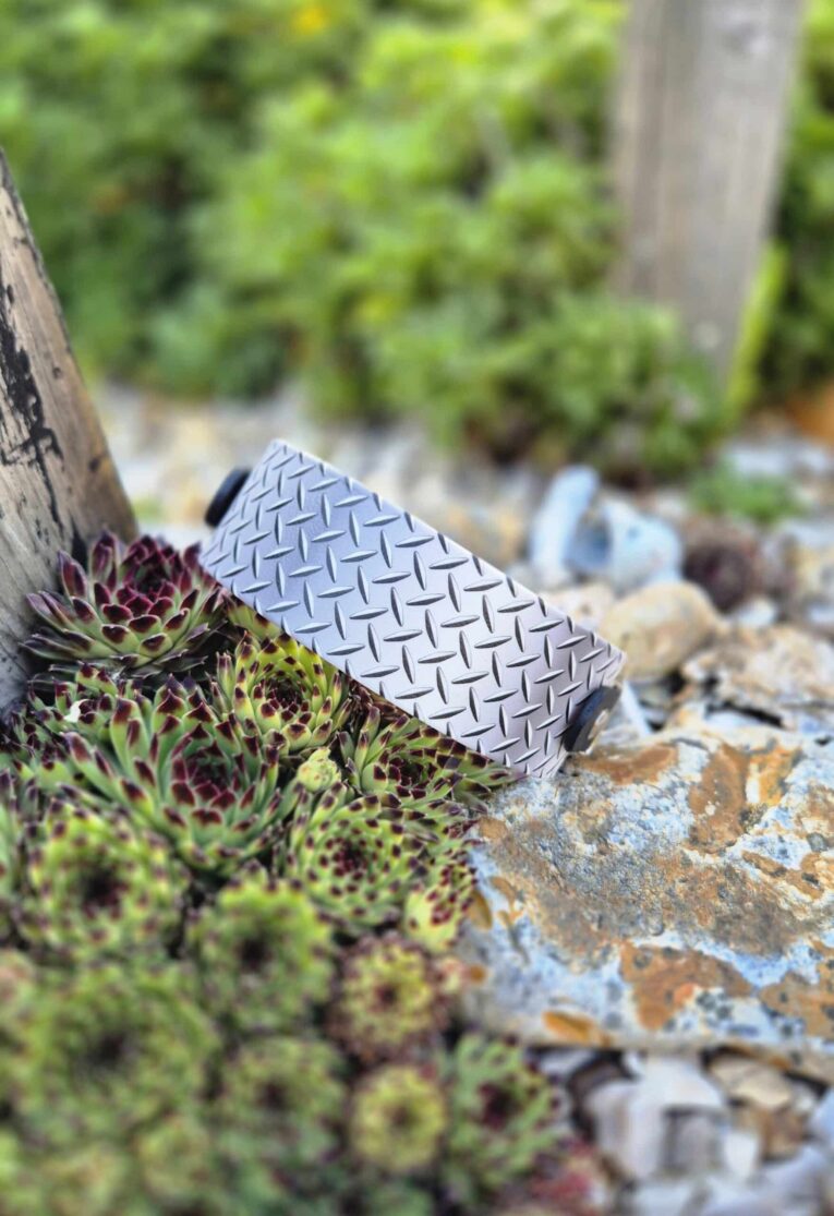 Printed BioThane hound collar with diamond plate pattern detail, displayed on moss-covered stone.