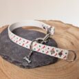 Handmade BioThane slip and clip dog collar with red horseshoe and star print design on natural wood.