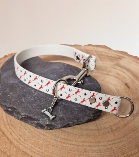 Handmade BioThane slip and clip dog collar with red horseshoe and star print design on natural wood.