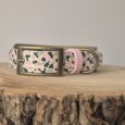 Printed hound collar in pink, cream and black patterned BioThane with bronze hardware, displayed on wooden surface.