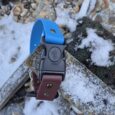 Blue quick release strap with BioThane handle attachment on snowy rocky ground.