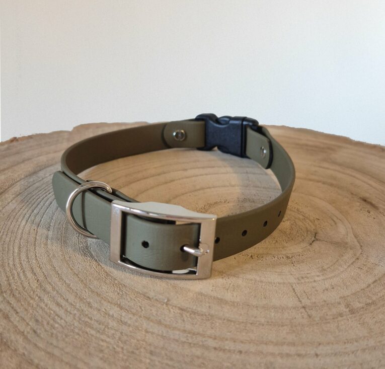 Waterproof BioThane dog collar with stainless steel buckle and D-ring, displayed on wooden surface.