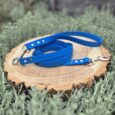 Blue waterproof longline with traffic handle and metal hardware on wooden display in natural setting.
