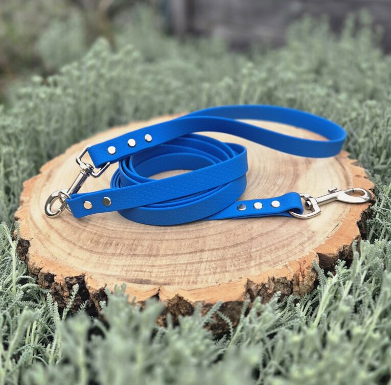 Blue waterproof longline with traffic handle and metal hardware on wooden display in natural setting.