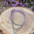 Lavender waterproof martingale dog collar with chain and ring detail on wooden log, garden setting.