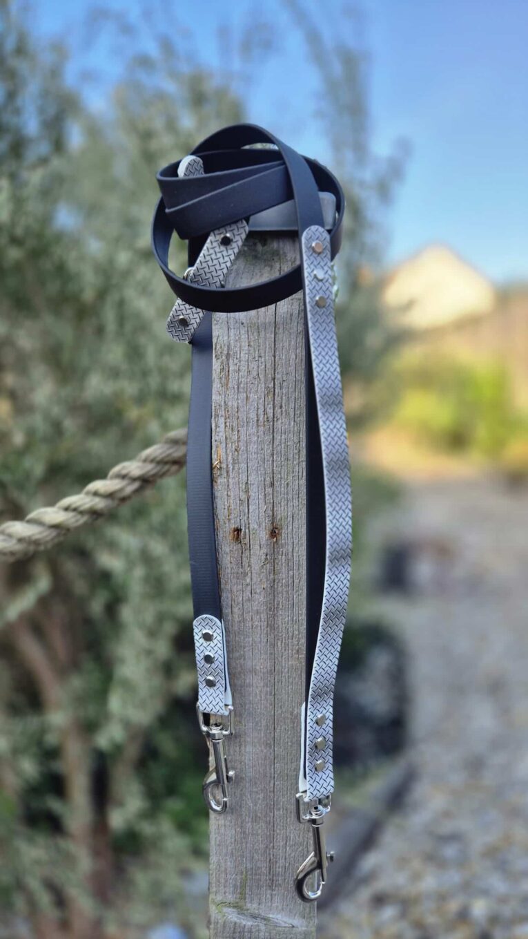 Waterproof printed BioThane lead with navy webbing and silver hardware, coiled around wooden post.