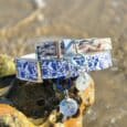Tails of the coast biothane collar in blue and white nautical print with matching personalised resin tag on coastal rock.