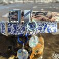 Tails of the coast BioThane collar with blue nautical pattern and matching tag displayed on coastal rocks by the sea.