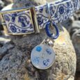 Nautical-themed BioThane dog collar with matching tag featuring maritime motifs, displayed on coastal rocks.