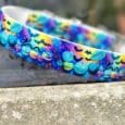 Vibrant Halloween-themed handmade BioThane dog collar featuring jack-o'-lanterns, bats, and autumn leaves in bold colours.