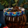 Handmade BioThane dog collar with vibrant Halloween-print design featuring pumpkins and bats, displayed on stacked books.