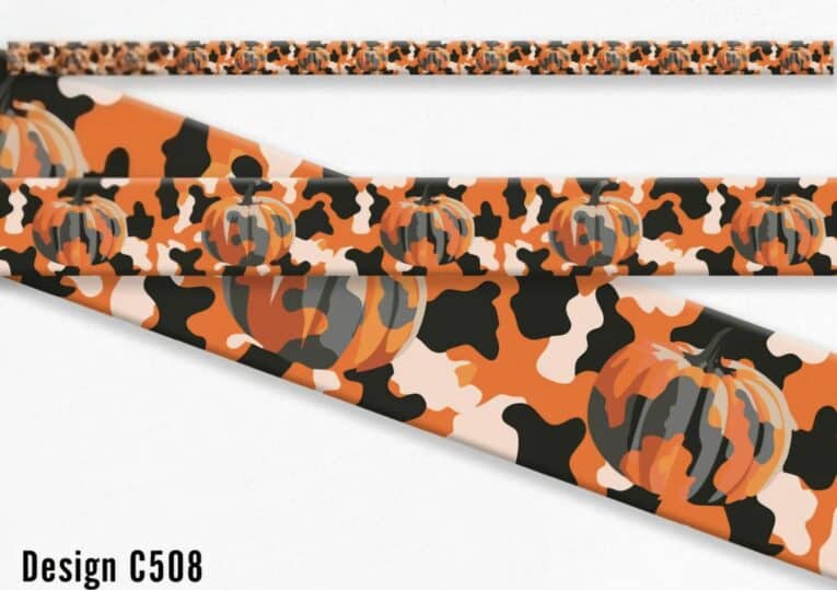 Handmade BioThane dog collar in orange with black and white cow print and pumpkin design details.