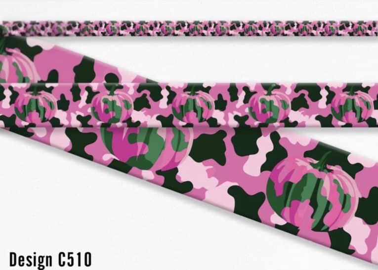 Pink pumpkin print handmade BioThane dog collar with black and green accents, displayed rolled.
