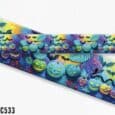 Vibrant Halloween-themed printed dog collar featuring jack-o'-lanterns, bats, spiders and tropical foliage in purple, yellow and teal tones.